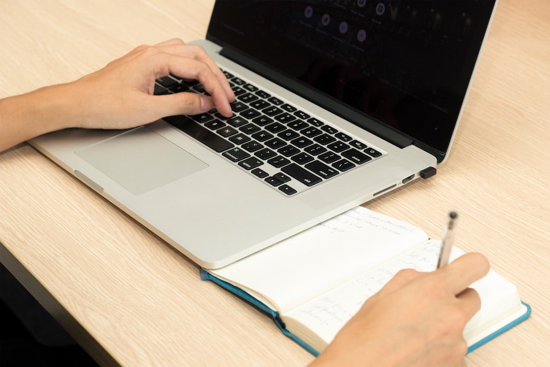 Pessoa escrevendo reportagem com notas e laptop